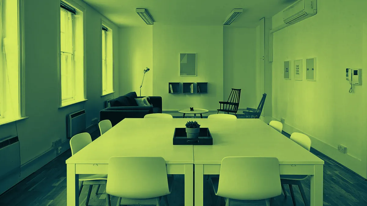 Sala de reuniones vacía con una mesa larga y sillas