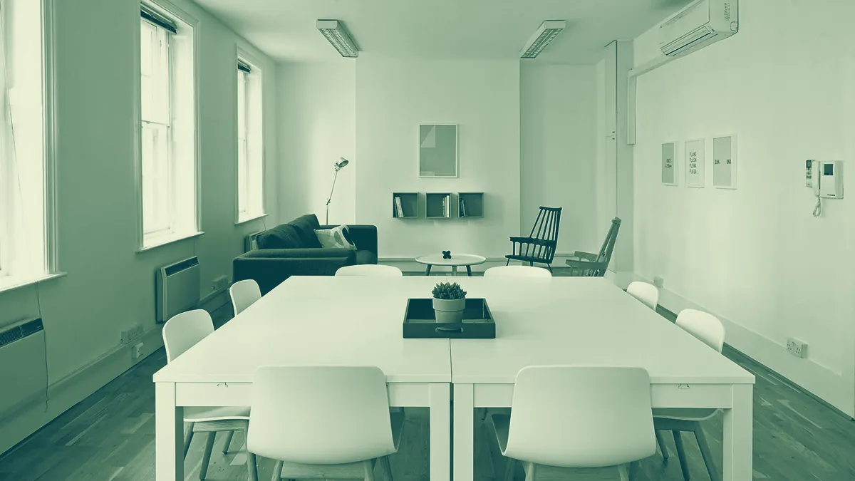 Sala de reuniones vacía con una mesa larga y sillas